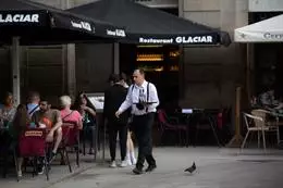 Un camarero sostiene una bandeja en la plaza Real de Barcelona, en una imagen de archivo. – David Zorrakino – Europa Press