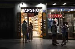 Varias personas en las puertas de una tienda, en Madrid (España). – Isabel Infantes – Europa Press