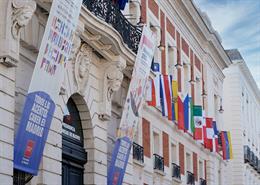 La Comunidad de Madrid ha engalanado la fachada principal de la Real Casa de Correos, sede del Gobierno regional, con las banderas de los 22 países hispanohablantes