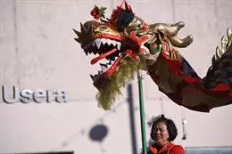 Archivo – Una mujer sujeta la cabeza de un dragón durante las celebraciones del Año Nuevo Chino en la plaza de Distrito de Usera. – Fernando Sánchez – Europa Press – Archivo