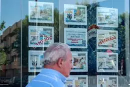 Un hombre camina frente a un escaparate de anuncios de viviendas. – Ricardo Rubio – Europa Press